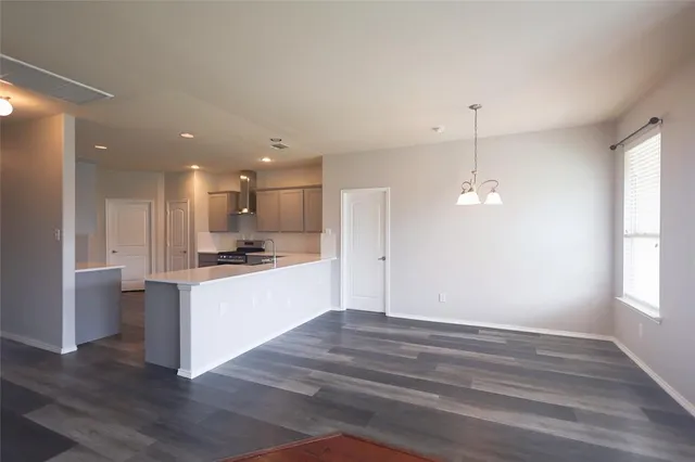 a view of kitchen with kitchen island stainless steel appliances refrigerator oven and cabinets