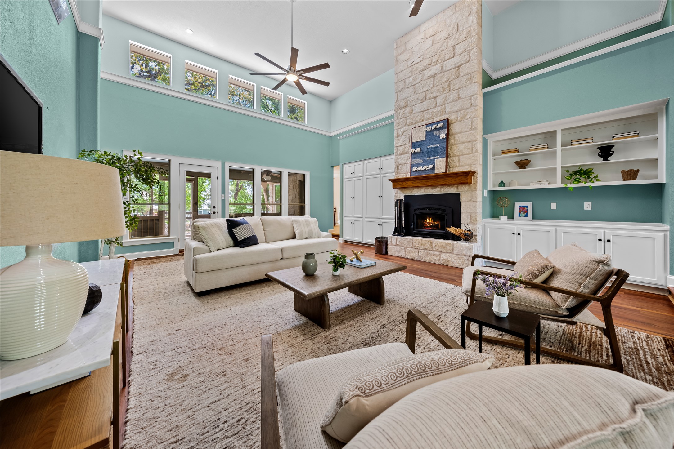 7670 Nez Perce Trace Manor, TX 78653 - Photo 7 of 40 Living room featuring ceiling fan, a stone fireplace, recessed lighting, wood finished floors, and a high ceiling