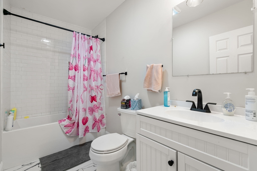 33 Gerald Road Boston, MA 02135 - Photo 3 of 19 a bathroom with a sink a toilet and shower curtain