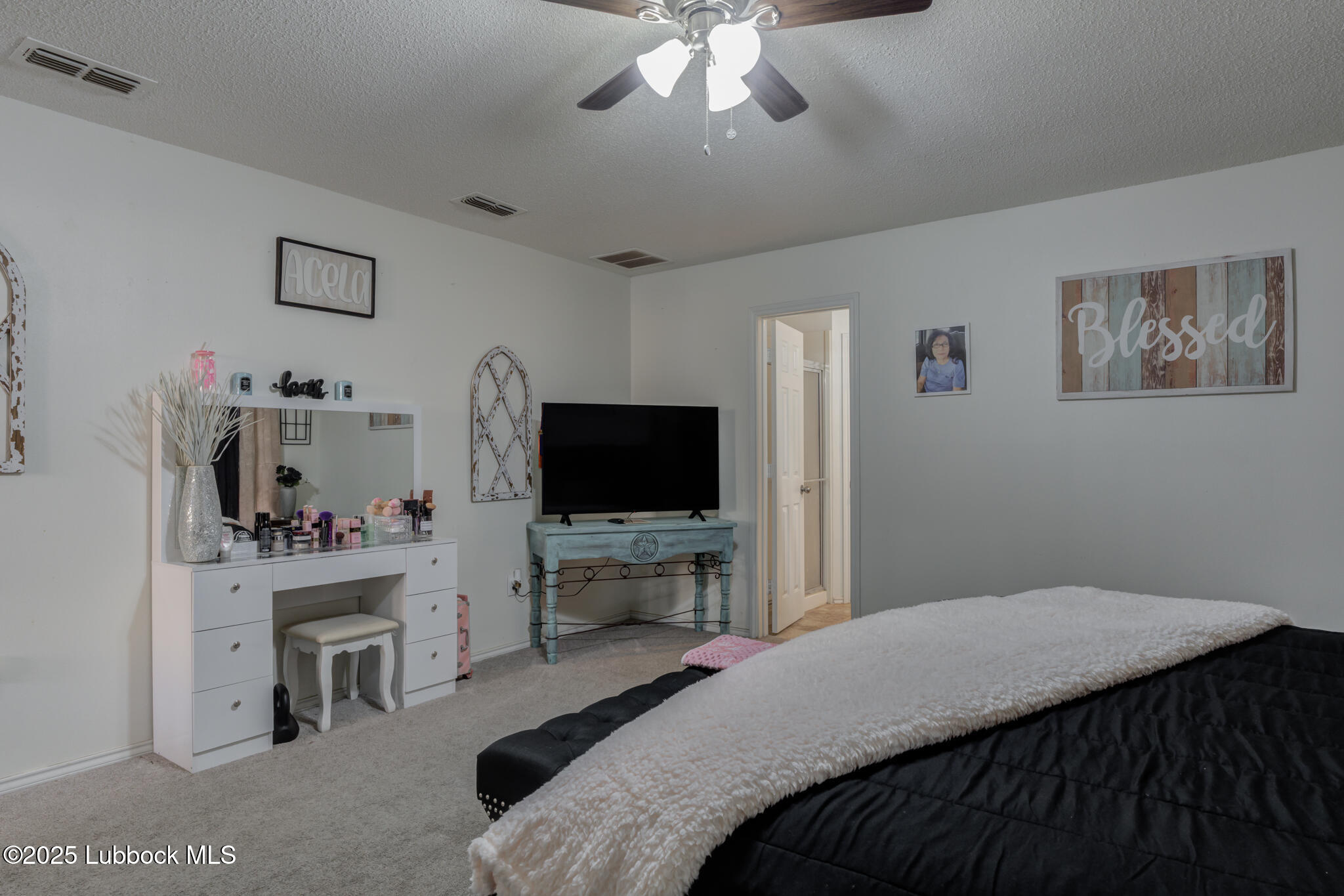 6223 18th Street Lubbock, TX 79416 - Photo 17 of 29 a bedroom with a bed and a flat screen tv