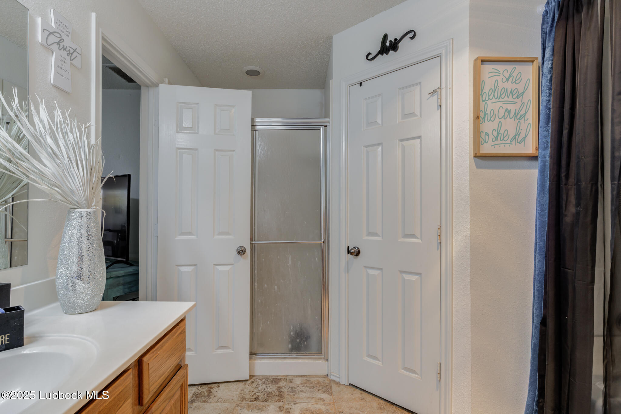 6223 18th Street Lubbock, TX 79416 - Photo 19 of 29 a bathroom with a granite countertop sink a shower and a mirror