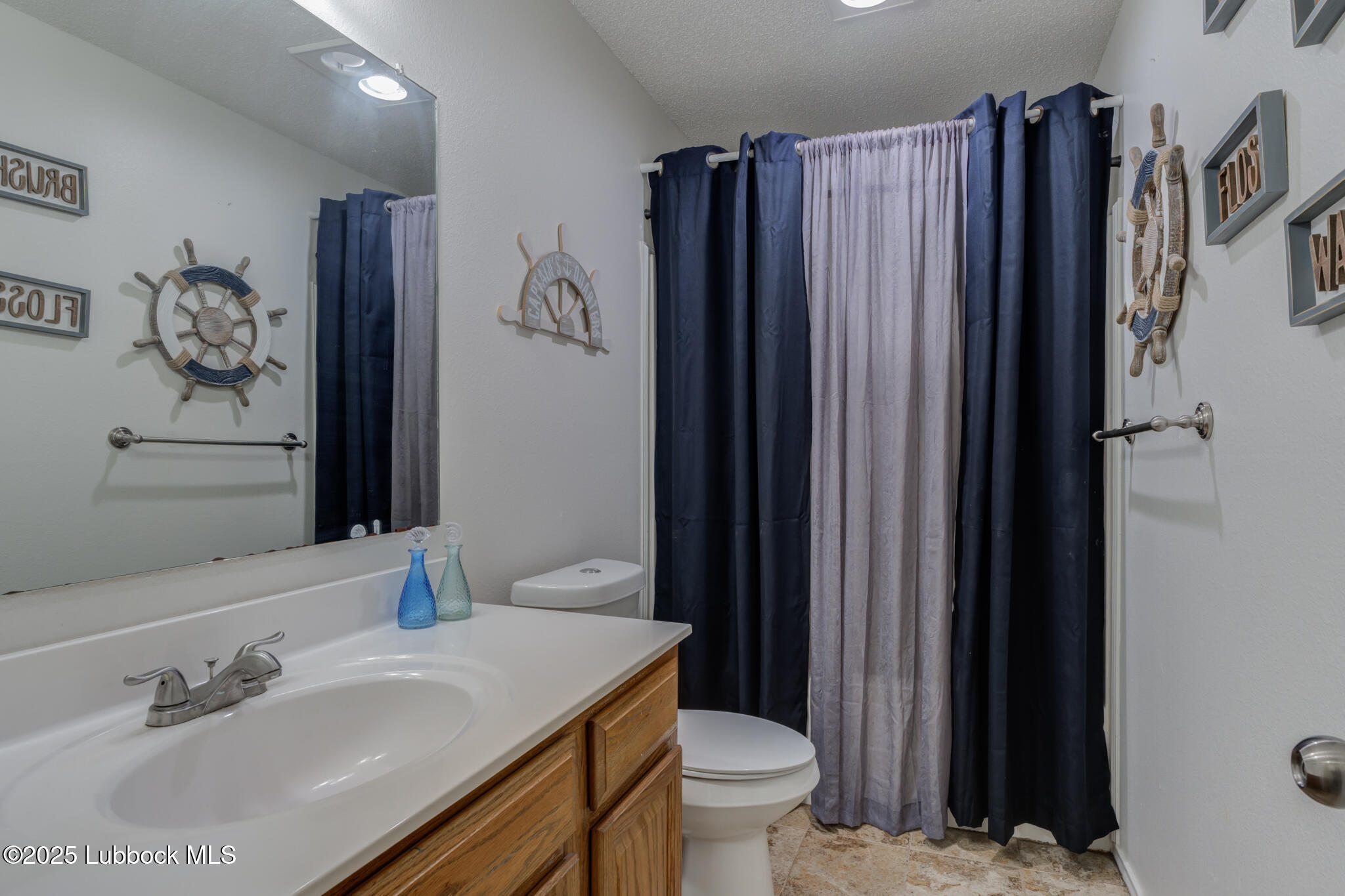 6223 18th Street Lubbock, TX 79416 - Photo 23 of 29 a bathroom with a sink toilet and shower