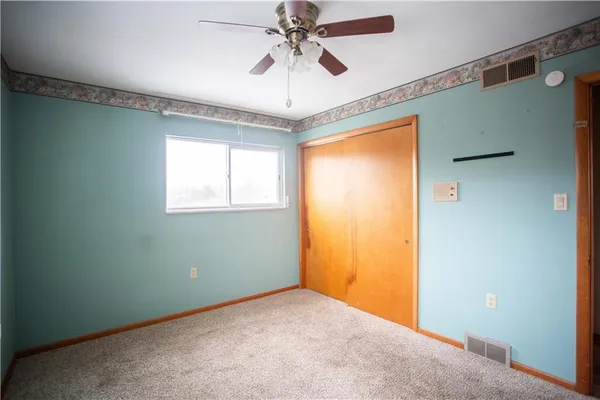 a view of a livingroom with a chandelier fan and a window