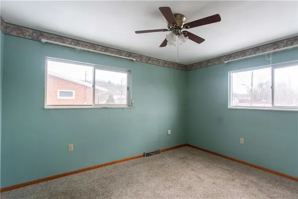 an empty room with a window and a fan