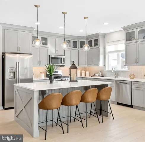 a kitchen with a table chairs refrigerator and microwave