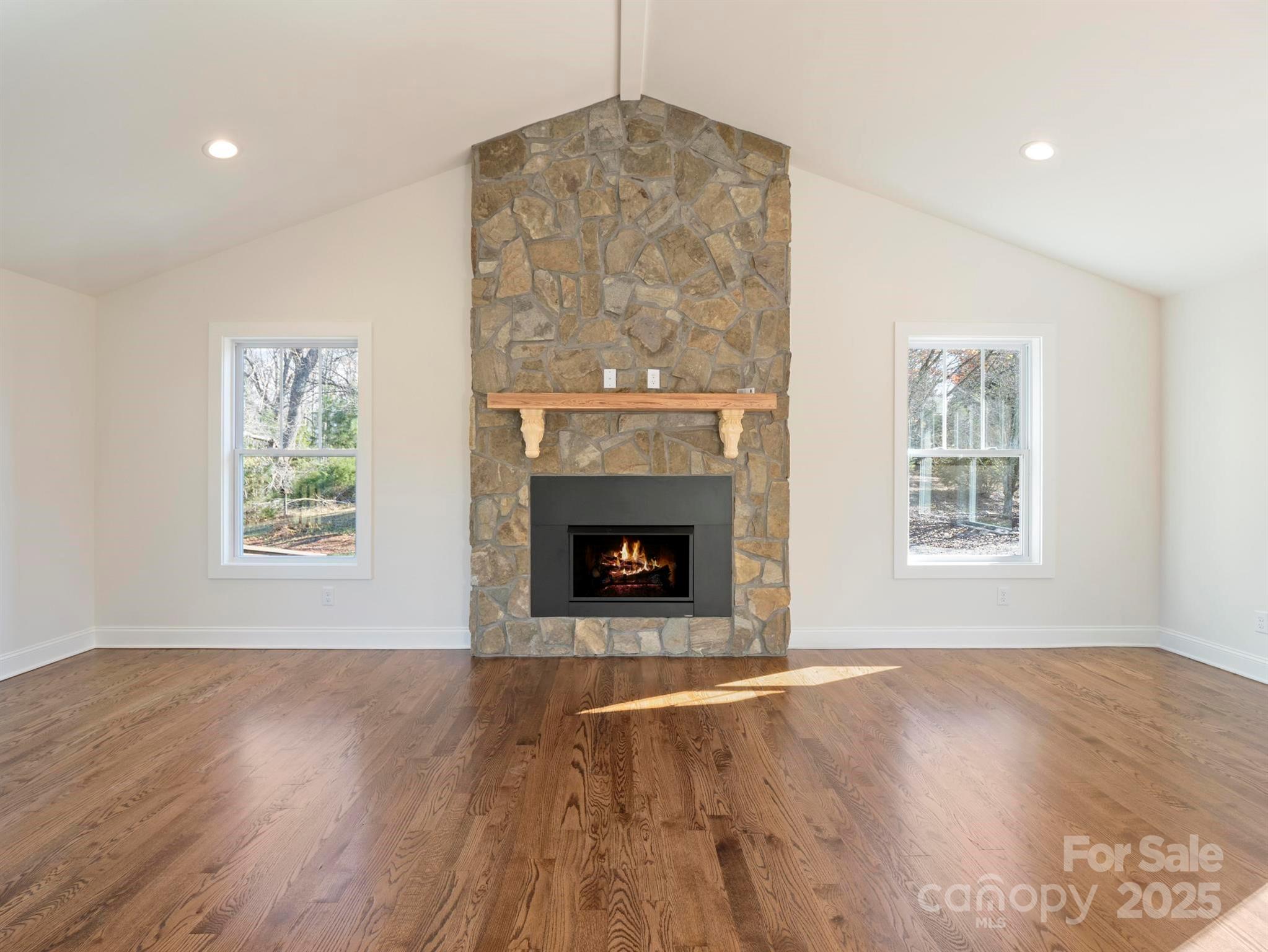 100 Gilbert Road Columbus, NC 28722 - Photo 5 of 24 a view of an empty room with wooden floor a fireplace and a window