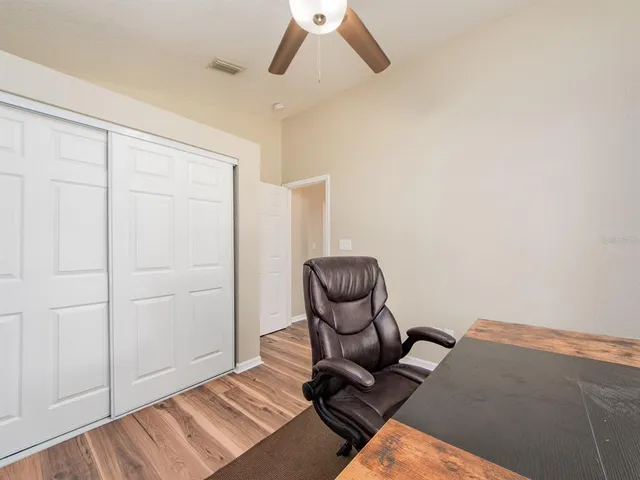 a view of a room with wooden floor and fan