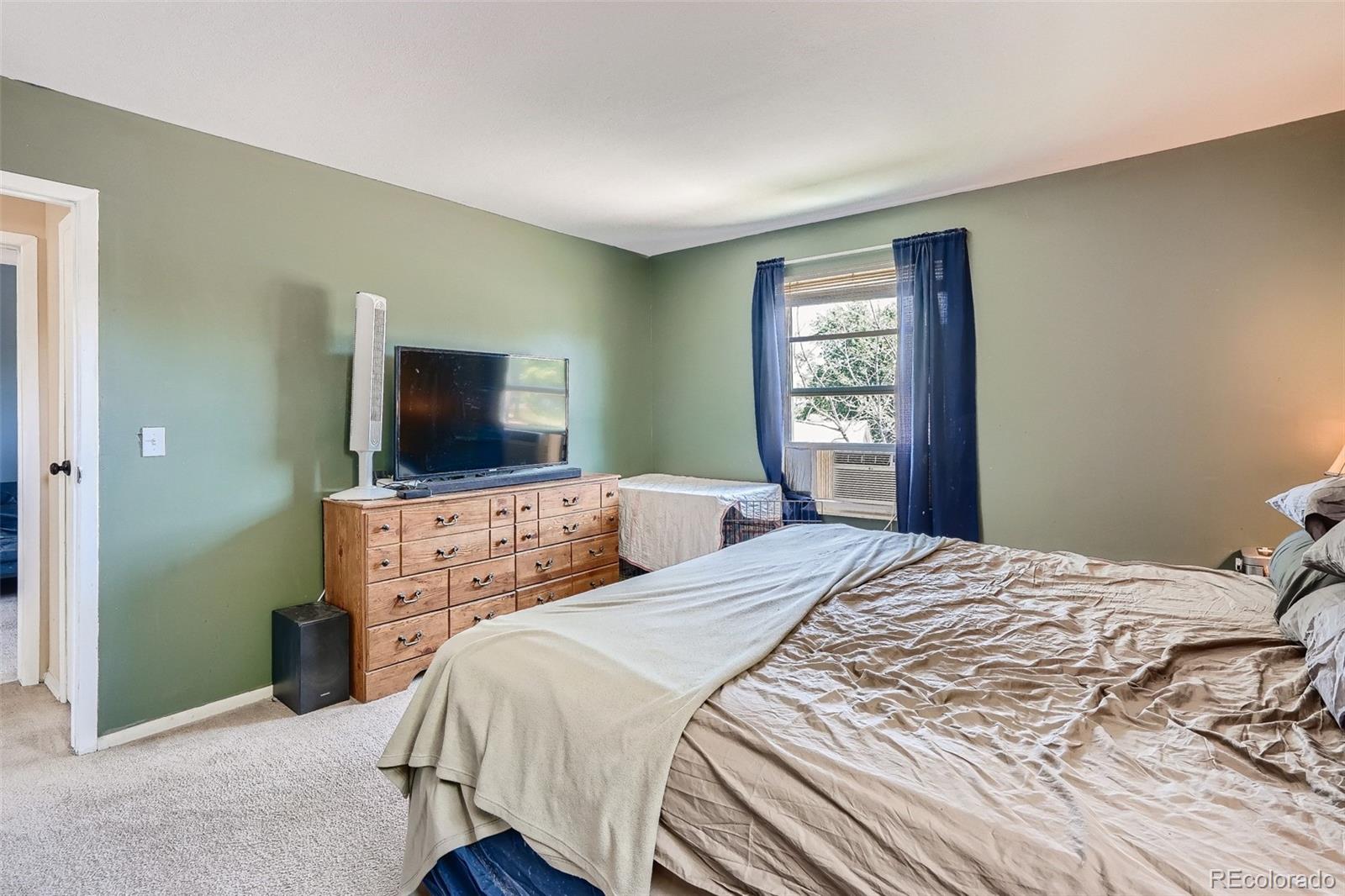 10541 Routt Street Westminster, CO 80021 - Photo 12 of 26 a bedroom with a bed and a flat screen tv
