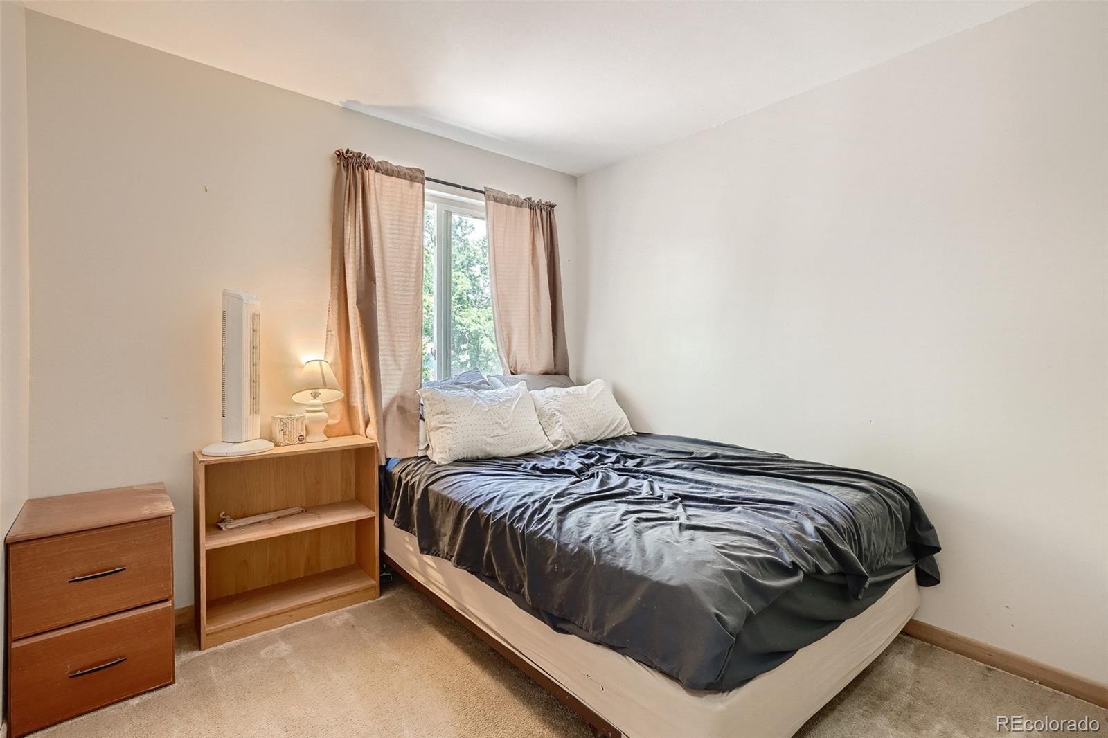 10541 Routt Street Westminster, CO 80021 - Photo 16 of 26 a bedroom with a bed and a window