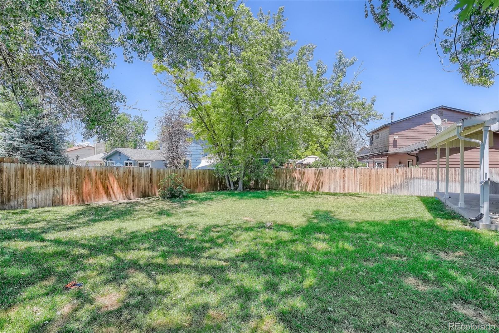 10541 Routt Street Westminster, CO 80021 - Photo 24 of 26 a view of a yard with a house and a large tree