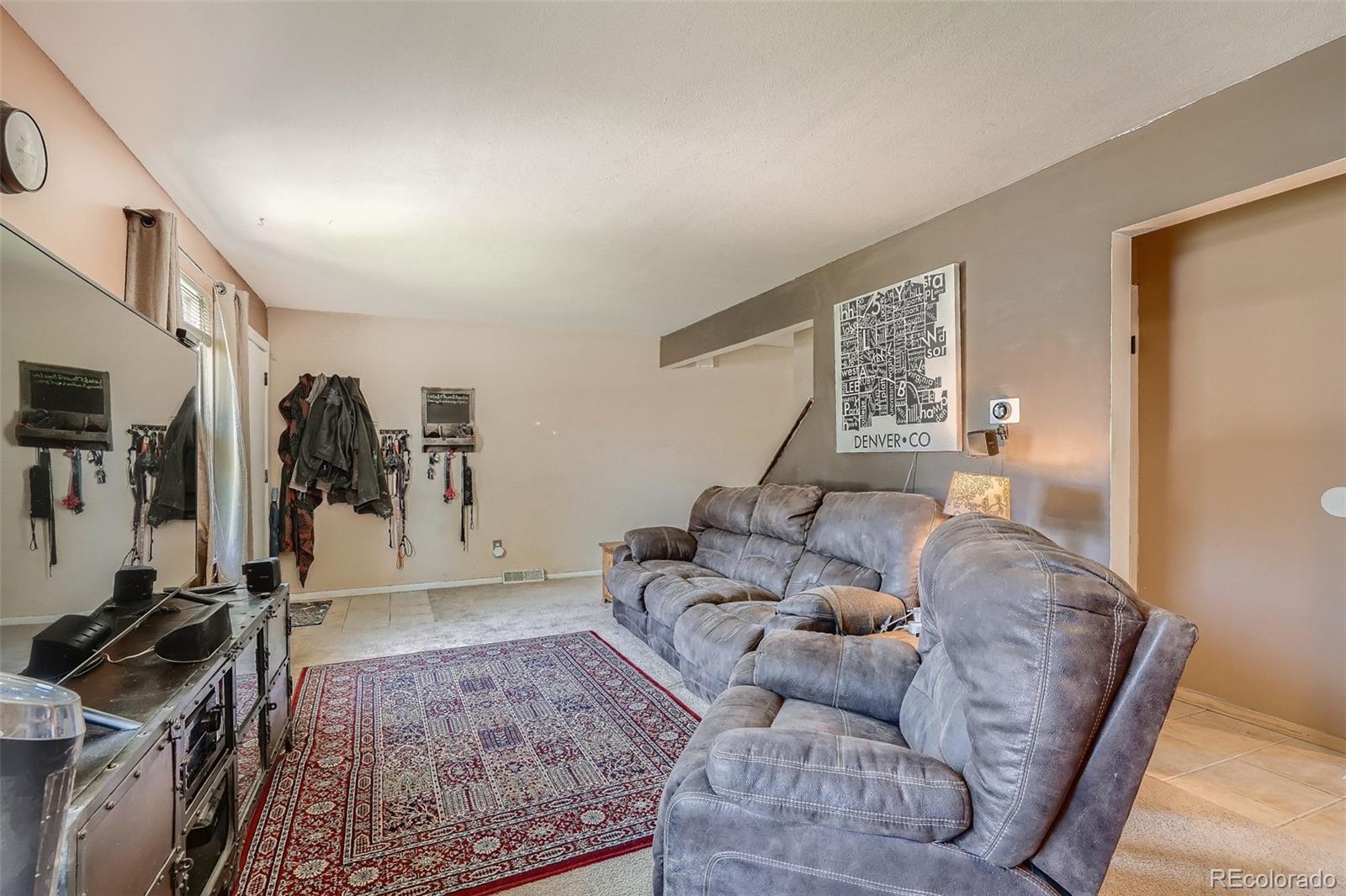 10541 Routt Street Westminster, CO 80021 - Photo 4 of 26 a living room with furniture and a flat screen tv