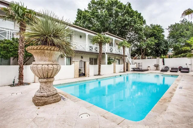 a view of a swimming pool with a fountain and plants