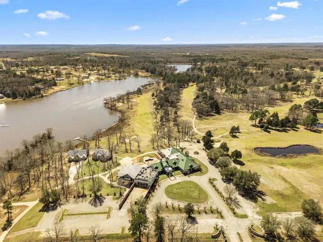 an aerial view of ocean and residential houses with outdoor space