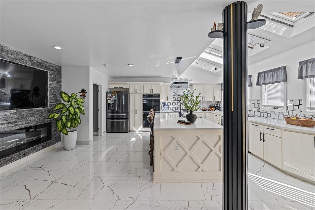 499 Madison Street Fall River, MA 02720 - Photo 13 of 38 a view of living room kitchen with furniture and flat screen tv
