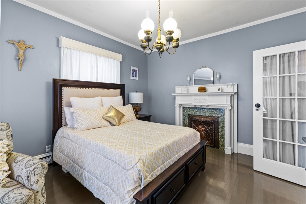 499 Madison Street Fall River, MA 02720 - Photo 20 of 38 a bedroom with a bed and a chandelier