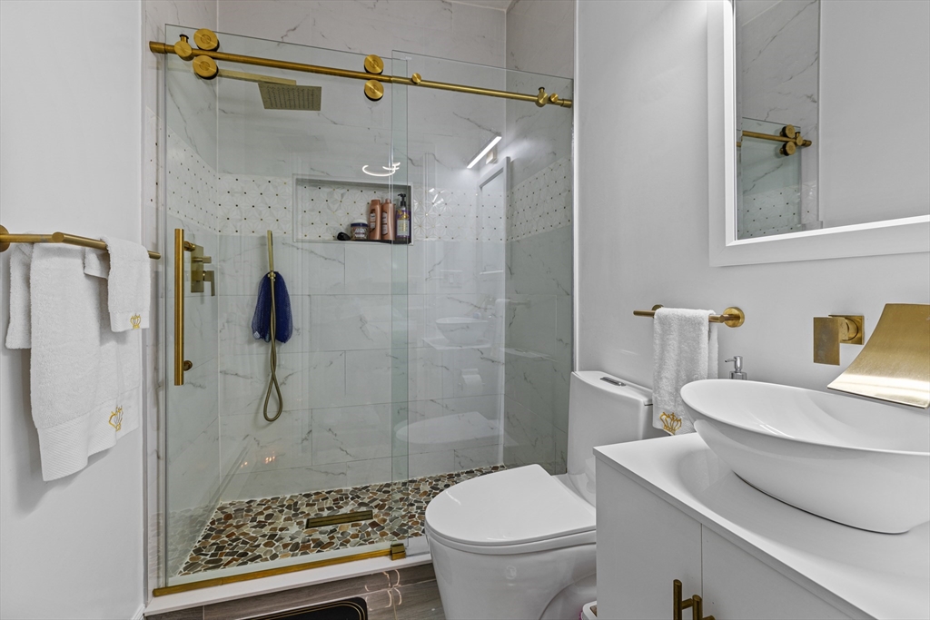 499 Madison Street Fall River, MA 02720 - Photo 27 of 38 a bathroom with a sink a toilet a shower and a mirror