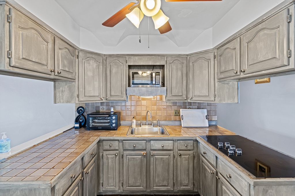 499 Madison Street Fall River, MA 02720 - Photo 33 of 38 a kitchen with stainless steel appliances granite countertop a sink a stove cabinets and wooden floor