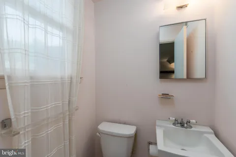 a bathroom with a sink toilet and mirror