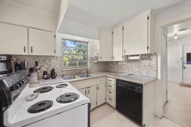 a kitchen with a sink a stove and cabinets
