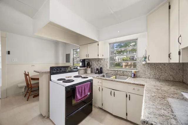 a kitchen with stainless steel appliances granite countertop a sink stove and cabinets