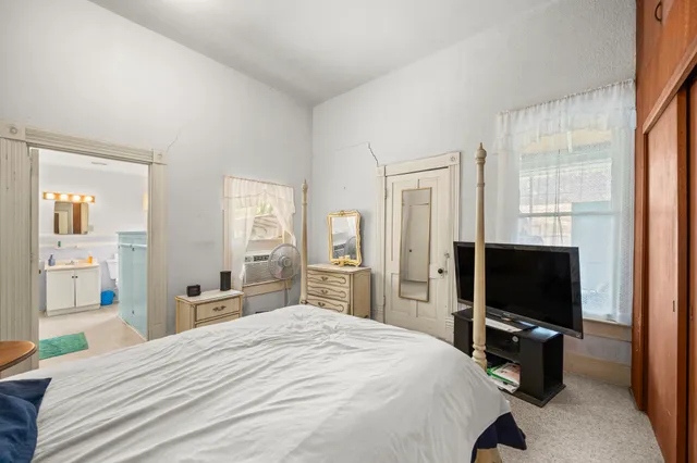 a bedroom with a bed and a flat screen tv