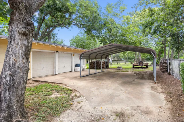 a view of a house with backyard and a trees