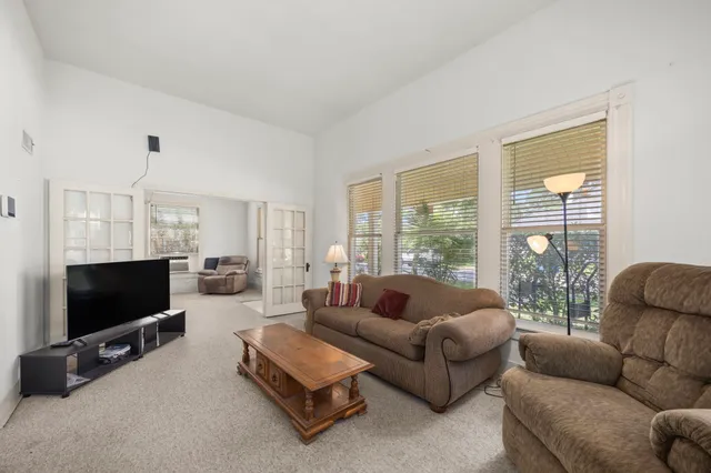 a living room with furniture a flat screen tv and a large window