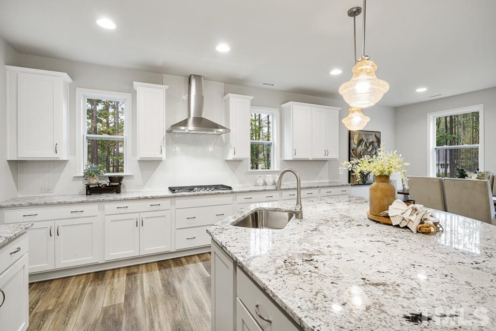 a kitchen with kitchen island granite countertop a sink a stove and cabinets