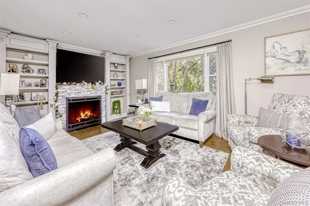 a living room with furniture a flat screen tv and a fireplace