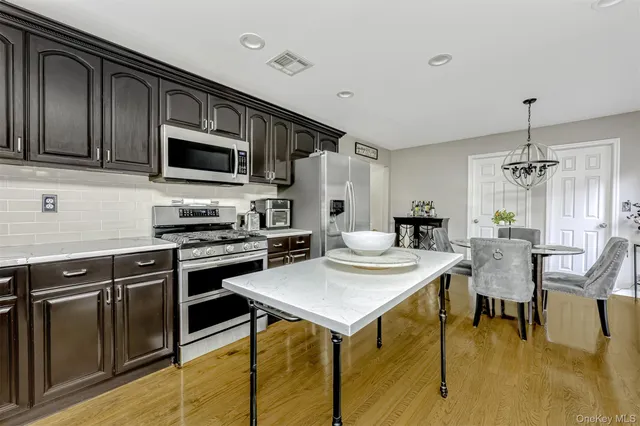 a kitchen with stainless steel appliances kitchen island granite countertop a sink and cabinets