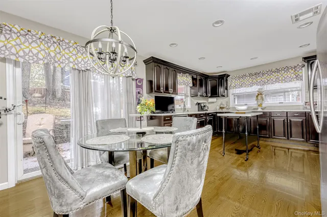 a view of a dining room with furniture a chandelier and wooden floor