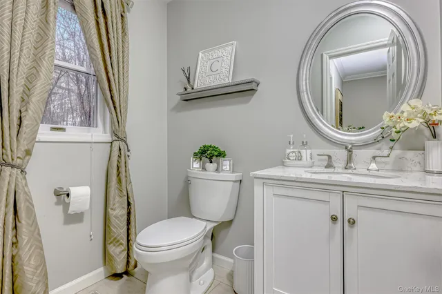 a bathroom with a toilet a sink and a mirror