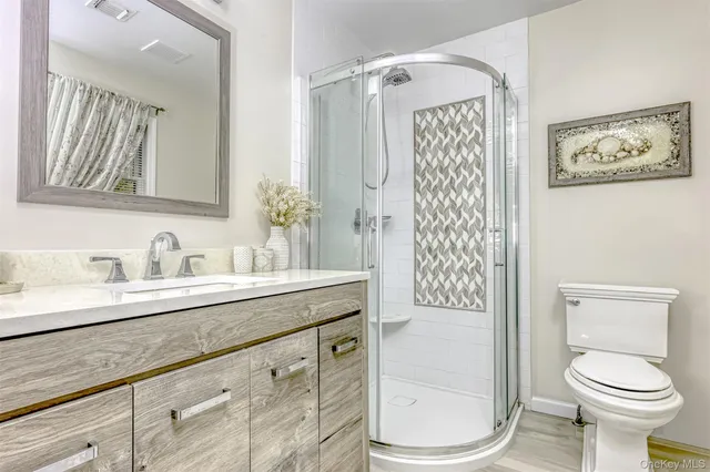 a bathroom with a granite countertop sink toilet and shower