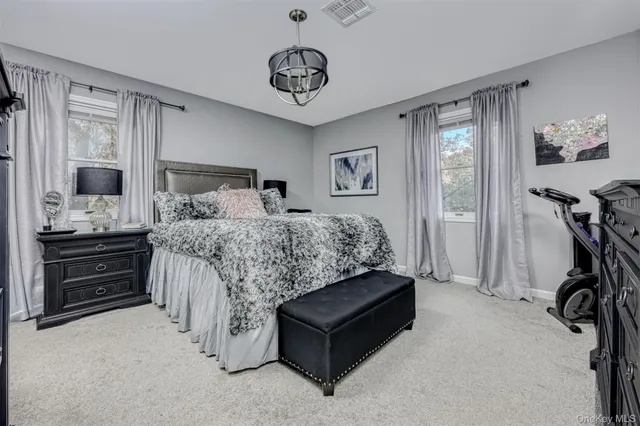 a bedroom with a bed and dresser with mirror