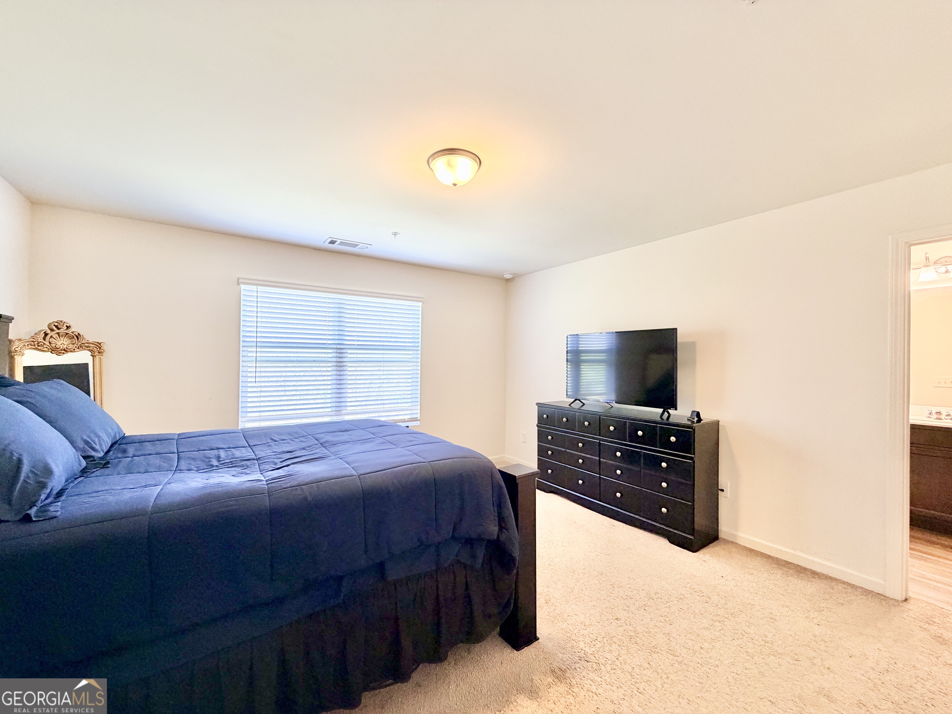 1601 Honeysuckle Path Conyers, GA 30012 - Photo 24 of 34 a bedroom with a bed and a flat tv screen on a dresser