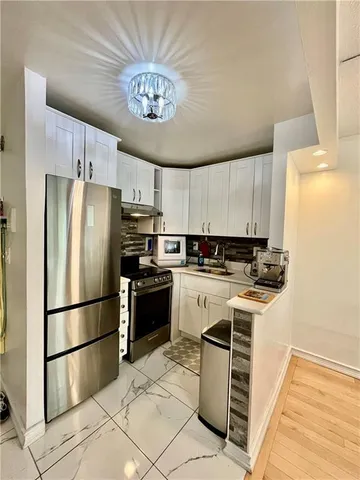 a kitchen with a refrigerator a stove and a sink