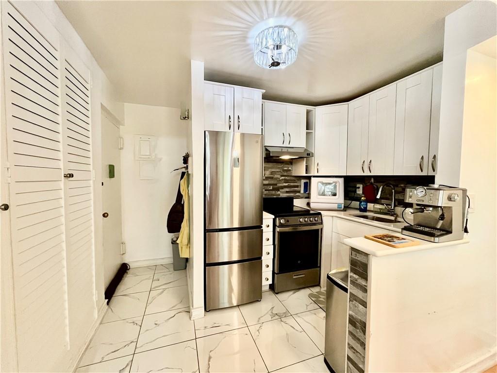 9965 Shore Road, Unit 6C Brooklyn, NY 11209 - Photo 17 of 37 a kitchen with a refrigerator a stove and a sink