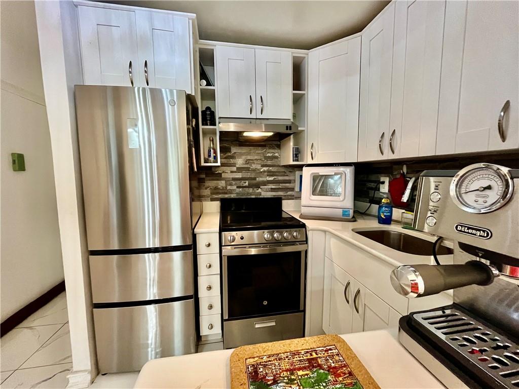 9965 Shore Road, Unit 6C Brooklyn, NY 11209 - Photo 18 of 37 a kitchen with stainless steel appliances granite countertop a refrigerator stove and sink