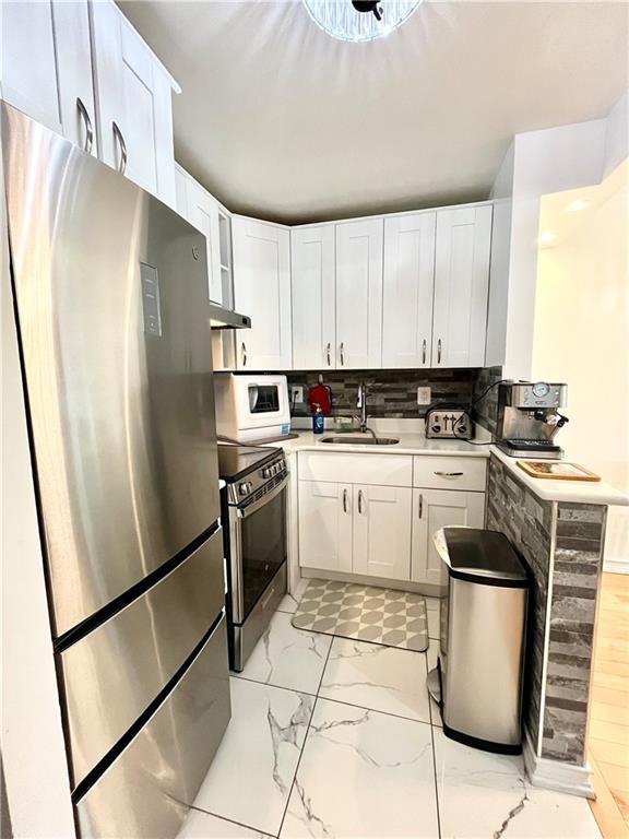 9965 Shore Road, Unit 6C Brooklyn, NY 11209 - Photo 19 of 37 a kitchen with a refrigerator sink and stove