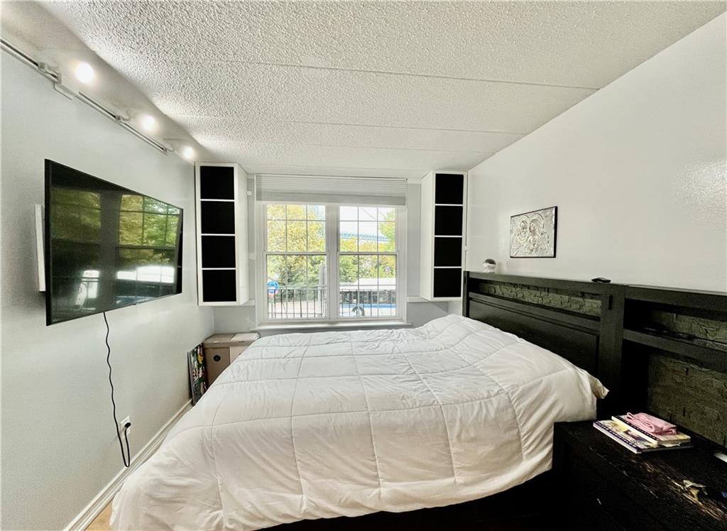 9965 Shore Road, Unit 6C Brooklyn, NY 11209 - Photo 22 of 37 a bedroom with a bed and a flat screen tv
