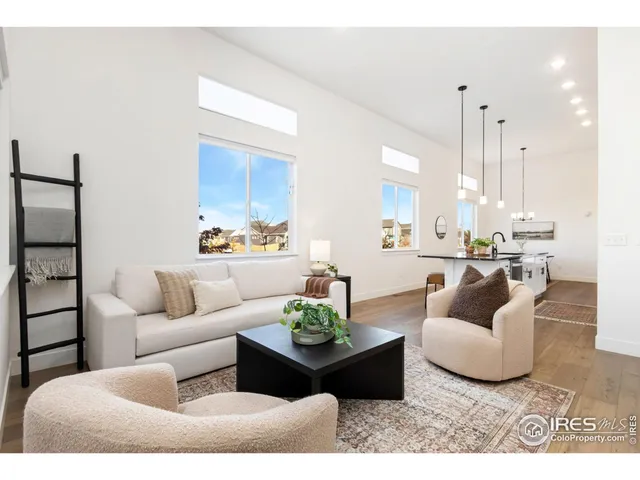 a living room with furniture kitchen view and a chandelier