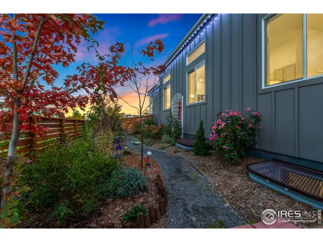 a backyard of a house with wooden fence and a table