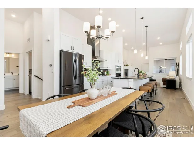 a dining room with kitchen island a chandelier dining table and chairs