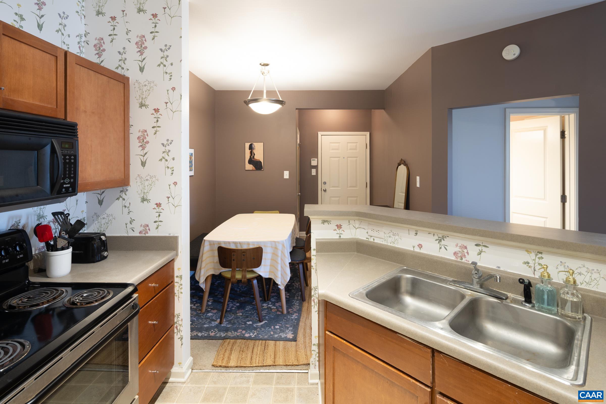 750 Walker Square, Unit 3D Charlottesville, VA 22903 - Photo 11 of 18 a kitchen with a sink and a stove top oven with wooden floor