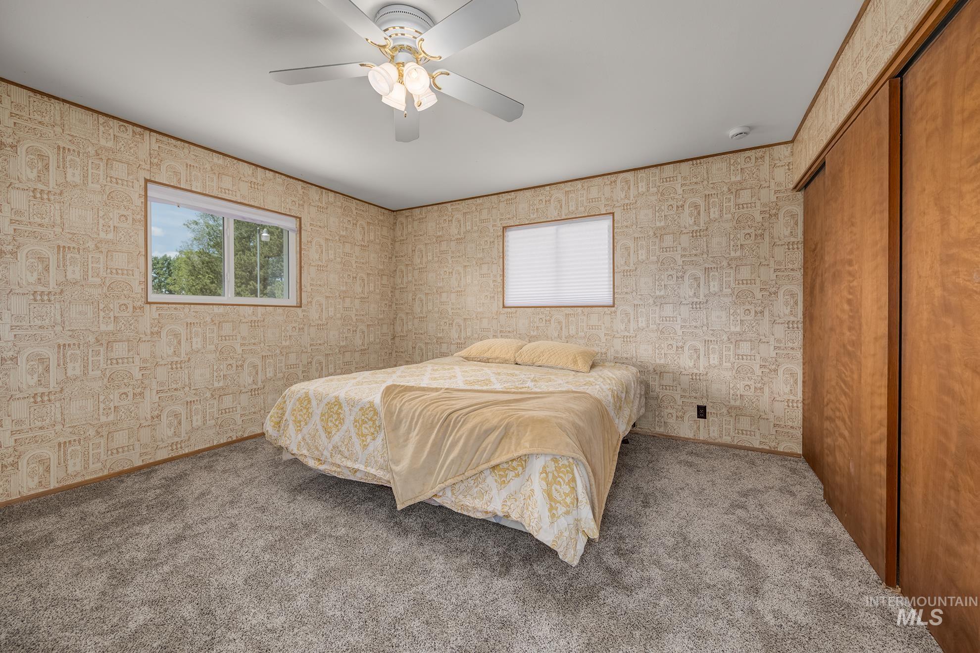 748 Pringle Road Weiser, ID 83672 - Photo 14 of 47 Bedroom featuring patterned wallpaper, carpeted flooring, and two windows