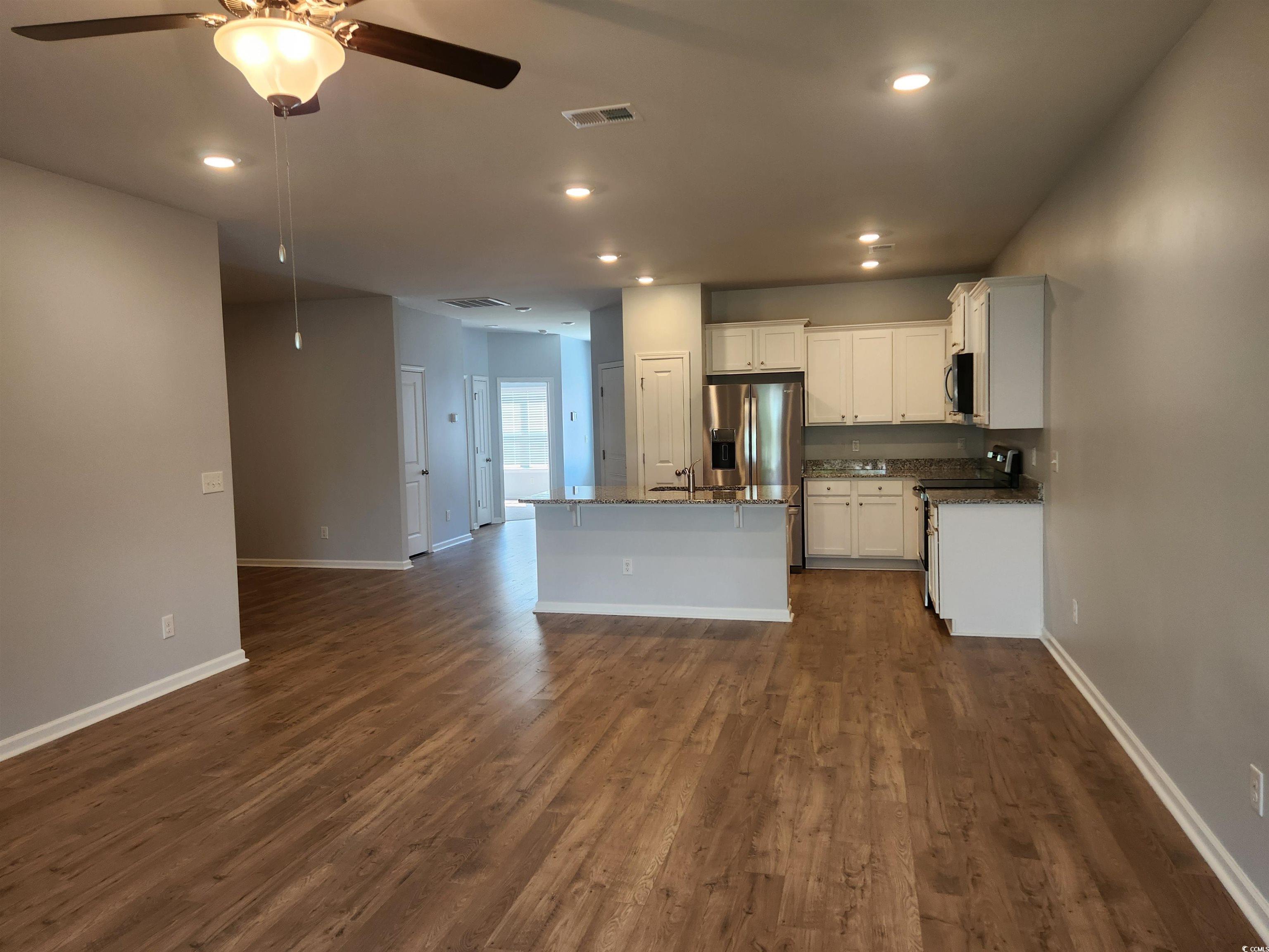 174 Sea Shell Drive Murrells Inlet, SC 29576 - Photo 3 of 16 Kitchen with ceiling fan, stainless steel appliances, dark wood-style flooring, a center island with sink, and white cabinetry