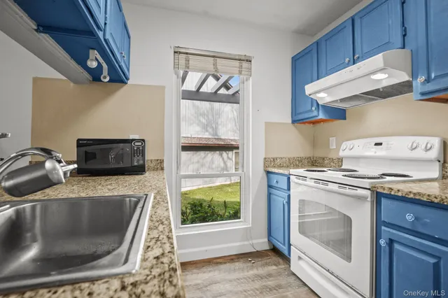 a kitchen with granite countertop a refrigerator and a sink