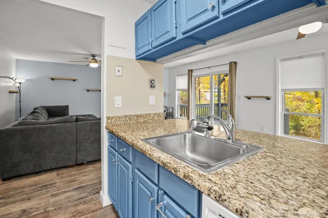 a kitchen with granite countertop a sink a stove and a microwave oven