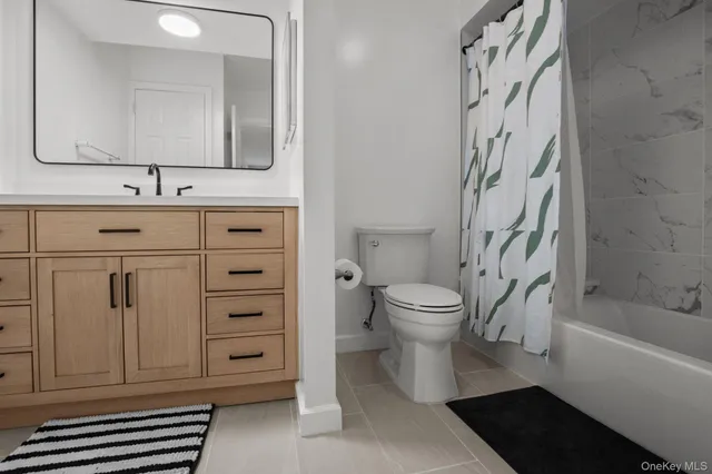 a bathroom with a bathtub sink vanity mirror and toilet