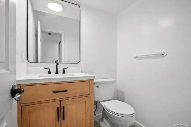 a bathroom with a toilet sink and mirror